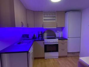 a purple kitchen with a sink and a refrigerator at Norðragøta in Norðragøta