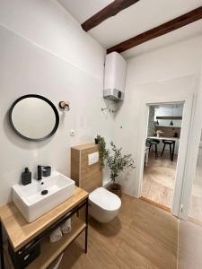 La salle de bains blanche est pourvue d'un lavabo et d'un miroir. dans l'établissement Agora, à Split