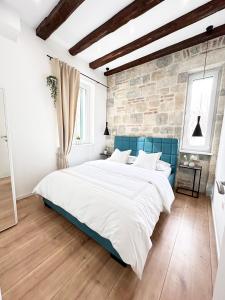 - une chambre avec un grand lit et un mur en briques dans l'établissement Agora, à Split