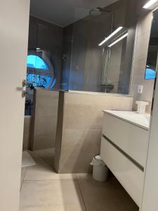 La salle de bains est pourvue d'un lavabo et d'un miroir. dans l'établissement Appartement de luxe avec parking, à Kayl