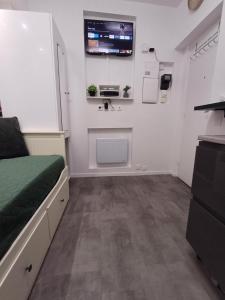 a bedroom with a bed and a sink and a tv at Bright small studio Paris Saint Ouen in Saint-Ouen