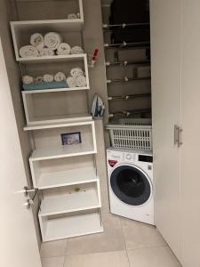 a laundry room with a washing machine and a washer at Appartement de luxe avec parking in Kayl