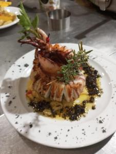 un plato de comida con un camarón en la parte superior en Pensión Xiquena, en Fiñana
