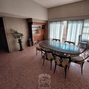a dining room with a glass table and chairs at Hostel De Oto in Godoy Cruz