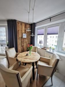 a dining room with a table and chairs at Mozaika Art Apartment PL LT EN in Suwałki