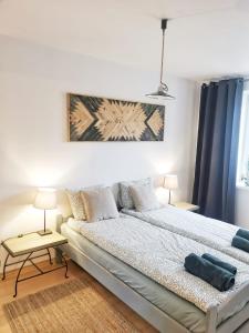 a bedroom with a large bed and two lamps at Mozaika Art Apartment PL LT EN in Suwałki