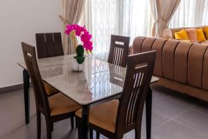 Shalom Villas في Mamobi: طاولة طعام مع كراسي و مزهرية مع الزهور