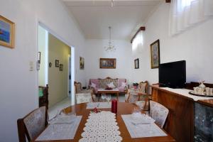 a dining room with a table and a living room at Haras House in Lefkada