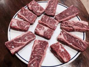 un plato de carne roja en una mesa de madera en Pensión Xiquena, en Fiñana