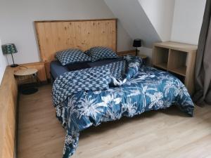 - une chambre avec un lit et une couette bleue et blanche dans l'établissement Gite aventure - Piscine chauffée - Parking privé, à Névez