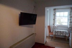 sala de estar con TV de pantalla plana en la pared en Haus Alpenblick en Ruhpolding