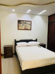 una camera con un letto e una foto appesa al muro di CASA MORALES a Santa Fe de Antioquia