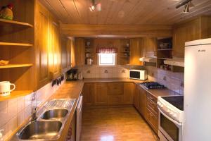 cocina grande con armarios de madera y fregadero en Kontakten by Norgesbooking - large cabin for families and groups, en Gol