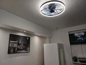a kitchen with a refrigerator and a ceiling light at Bright small studio Paris Saint Ouen in Saint-Ouen