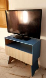 a flat screen tv sitting on top of a blue cabinet at Hospedagem Rio Lapa in Rio de Janeiro