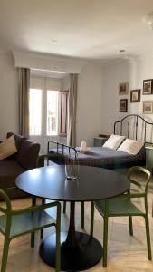 uma sala de estar com uma mesa e uma cama em Casa Cervantes Malaga em Málaga