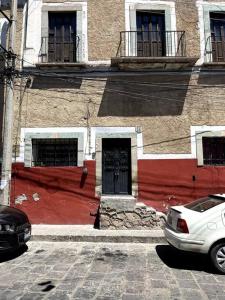 a white car parked in front of a building with a door at Casa colonial céntrica Guanajuato in Guanajuato