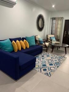a living room with a blue couch and a rug at Meadows Place in Montego Bay