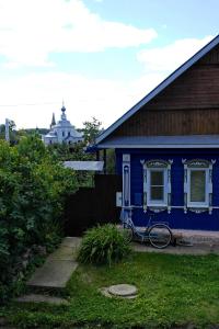 a blue house with a bike parked in the yard at Guest House Varvarinskiy in Suzdal