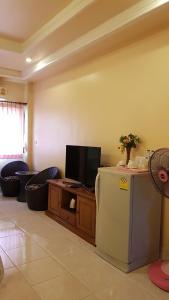 een woonkamer met een koelkast en een televisie bij Kasithorn Apartment&Hotel in Phetchabun