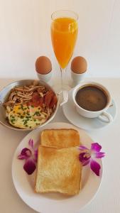 a table with a plate of breakfast food and a cup of coffee at Kasithorn Apartment&Hotel in Phetchabun
