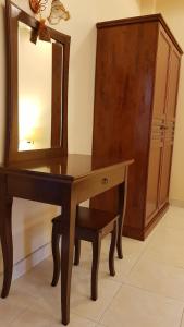 Kasithorn Apartment&Hotel في بيتشابون: طاولة تزيين خشبية مع مرآة وخزانة