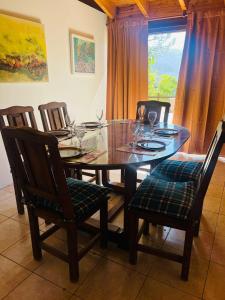 comedor con mesa, sillas y ventana en Chalet Villalís en Potrerillos