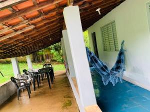 a patio with tables and chairs and a swimming pool at Chácara Vale dos Eucaliptos in Pouso Alegre
