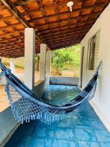 a hammock on a porch of a house at Chácara Vale dos Eucaliptos in Pouso Alegre