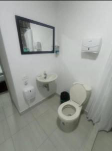 a white bathroom with a toilet and a sink at Hotel Confort Boutique in Rionegro
