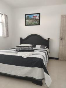 a bed with a black and white comforter in a bedroom at Hotel Confort Boutique in Rionegro