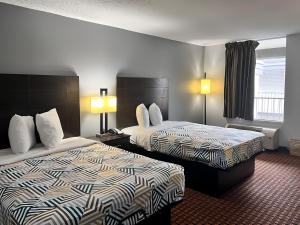 a hotel room with two beds and two lamps at Motel 6 Chickasha, OK in Chickasha