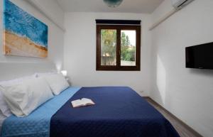 sypialnia z niebieskim łóżkiem z kapeluszem w obiekcie Casa Mediterraneo Santa Teresa di Gallura w mieście Porto Pozzo
