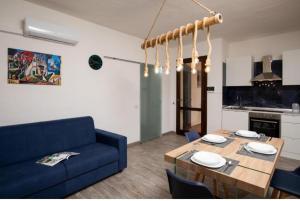 a living room with a blue couch and a table at Casa Mediterraneo Santa Teresa di Gallura in Porto Pozzo