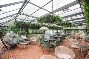 a conservatory with tables and chairs and plants at Kyah in Blackheath