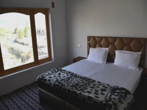 a bedroom with a large bed with a large window at POP HOME 81129A Skayil Guest House in Nubra