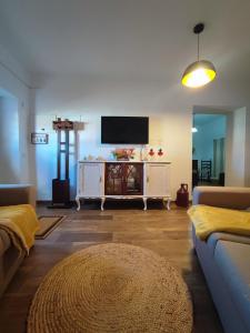a living room with a couch and a tv at Casa Tia Xica in Monsaraz