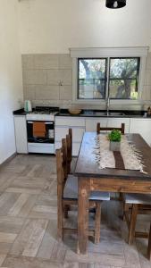 a kitchen with a wooden table with chairs and a stove at 12 Olivos Cabañas in San Rafael +37 photos