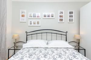 a bedroom with a bed with two lamps and pictures on the wall at Apartment Martini in Split