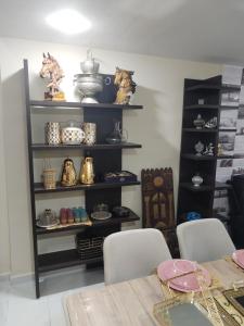 a dining room with a table and shelves of ceramics at شقة رائعة داخل فيلا مستقلة in Casablanca