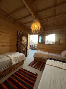 1 dormitorio con 2 camas en una cabaña de madera en Heaven Surf Camp, en Agadir