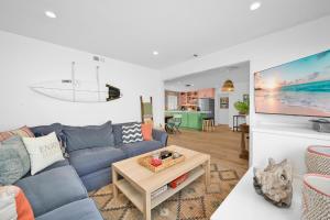 ein Wohnzimmer mit einem blauen Sofa und einem Tisch in der Unterkunft Chic Modern Designed Home with Private Studio in Newport Beach