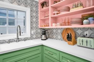 a kitchen with green cabinets and pink shelves at Chic Modern Designed Home with Private Studio in Newport Beach +41 photos