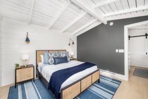 a bedroom with a king sized bed with blue pillows at Balboa Island Luxury Penthouse Suite With Bay Views in Newport Beach