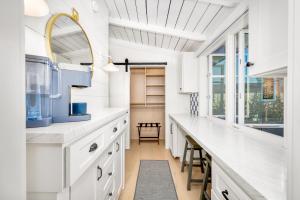 una cucina con banconi bianchi e una grande finestra di Balboa Island Luxury Penthouse Suite With Bay Views a Newport Beach