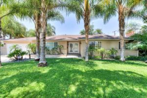 a house with palm trees in a yard at Palm Villa Disneyland Pool 4 Bedroom 3 Bath HotTub in Anaheim