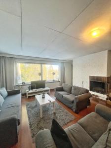 a living room with two couches and a fireplace at Nice and cozy big house for 8 people with sauna in Vantaa