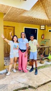 a group of three people standing in front of a house at MIKI's Guest House in Siquijor