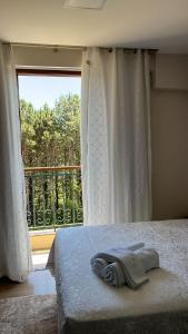 a bedroom with a bed and a large window at Flat Pedra Azul in Aracê