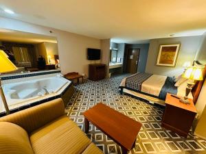 a hotel room with a bed and a tub at Royal Inn Suites in Huntington